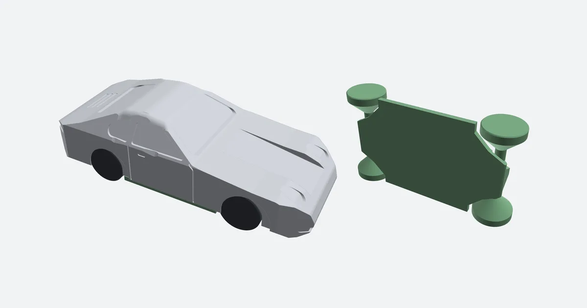 A 911 model from the chassis tool on black wheels, and beside it the green chassis with its four wheels as it prints